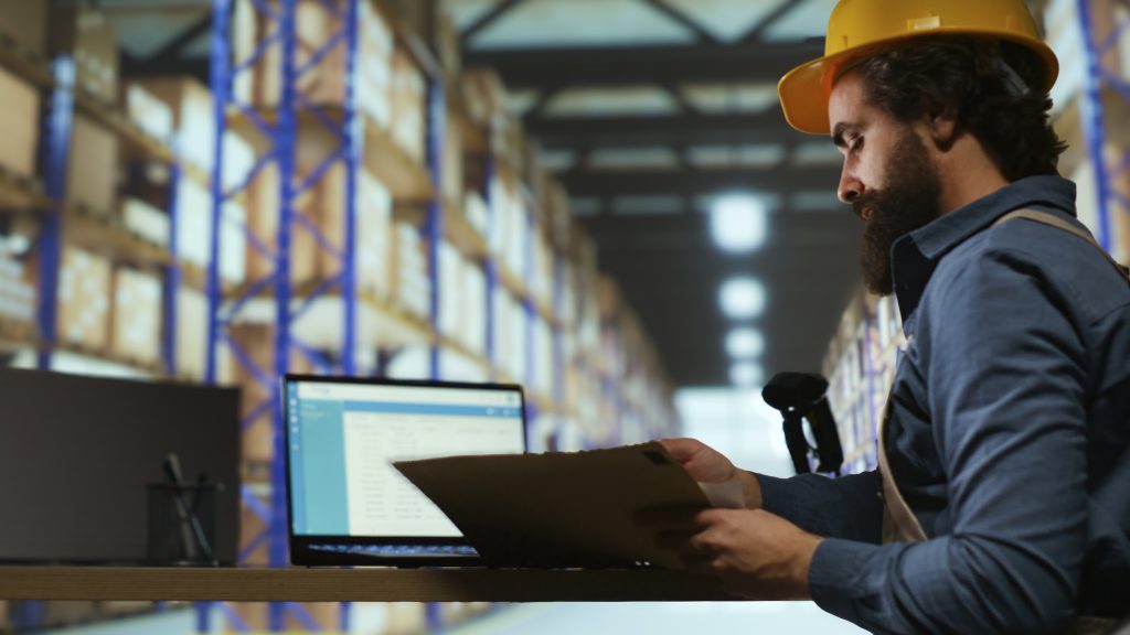 Delivery service associate examines order details on files